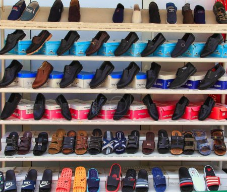 Téléchargez les photos : Achgabat, marché du Turkménistan - Mart 15.2020 : Étagères dans un magasin avec une variété de chaussures pour hommes - en image libre de droit