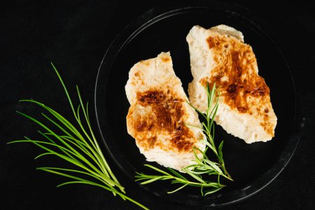 Photo for Chicken fillets fried until half cooked,product.Quick cooking at home.Semi-finished chicken fillets,lightly fried,on a dark background with fresh herbs.Half-finished.Quick cooking at home.Fast food. - Royalty Free Image