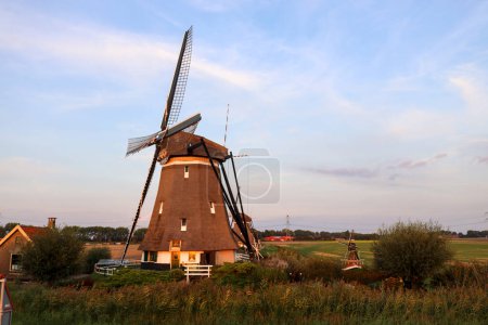 Foto de Puesta de sol sobre los molinos de viento molenviergang del Tweemanspolder en Zevenhuizen en te Países Bajos - Imagen libre de derechos