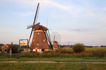 Foto de Puesta de sol sobre los molinos de viento molenviergang del Tweemanspolder en Zevenhuizen en te Países Bajos - Imagen libre de derechos