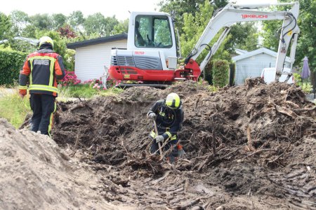 Photo for Firefighters must take action if a gas pipe is hit during excavation work at Park de IJsselhoeve in Nieuwerkerk aan den IJssel the Netherlands - Royalty Free Image