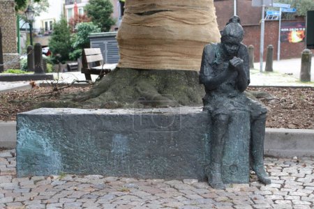 Photo for Statue Girl with finch by Roel Bendijk, the finch refers to the construction company Frans Vink en Zonen, on the church square in Moordrecht in the Netherlands - Royalty Free Image