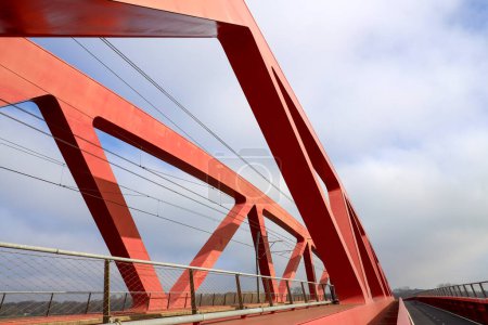 Red steel bridge called Hanzeboog over the river IJssel between Hattem and Zwolle in the Netherlands