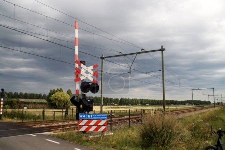 Photo for Barriers and red lights at railroad crossing in Moordrecht in the Netherlands - Royalty Free Image