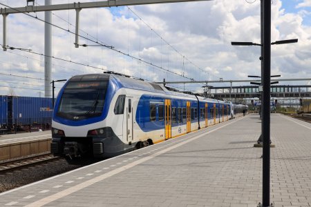 Foto de Coquetear trenes de cercanías de NS llamado Sprinters en la estación Lage Zwaluwe en los Países Bajos - Imagen libre de derechos