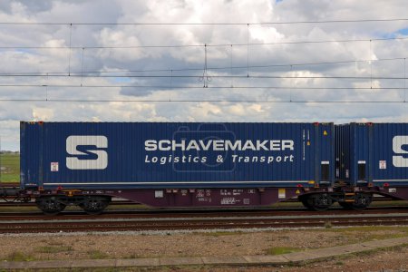 Foto de Contenedores de mercancías en vagones de tren en la estación de tren de Lage Zwaluse en los Países Bajos. - Imagen libre de derechos