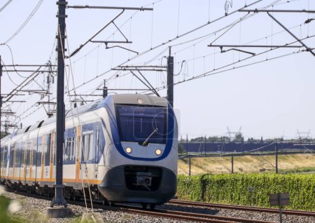 Téléchargez les photos : Train de banlieue SLT sur voie ferrée près de Zwolle géré par NS - en image libre de droit