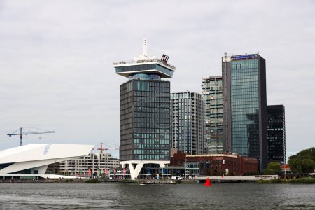 Foto de Edificios de oficinas en Amsterdam en el agua IJ con ferry y barco turístico en los Países Bajos - Imagen libre de derechos