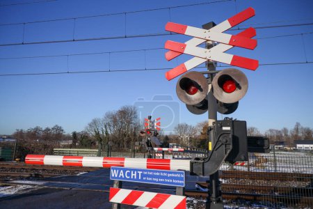 Foto de Cruce ferroviario con luces rojas y barrera en el Zuidplaspolder las tierras bajas - Imagen libre de derechos