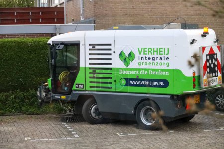 Téléchargez les photos : Balayeuse et machine à brosser de Verheij sur la rue à nieuwerkerk pour enlever les mauvaises herbes entre les pierres dans les Pays-Bas - en image libre de droit