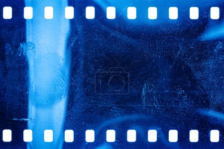 Staubige und grunzige 35mm Filmstruktur oder -oberfläche. Perforierte zerkratzte Kamerafolie isoliert auf weißem Hintergrund.