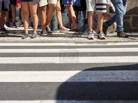 Foto de Muchas personas caminando en el centro de la ciudad de Oporto. Los peatones cruzan la concurrida calle en el cruce peatonal en el centro de la ciudad de Oporto, Portugal - Imagen libre de derechos