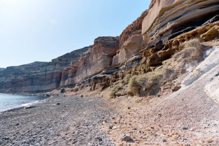 Vista de la playa de arena negra (Playa Mesa Pigadia). Su nombre al color de la arena y las rocas verticales que se ciernen sobre ella. Islas griegas, Santorini, Vacaciones europeas