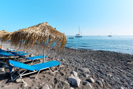 Vista con playa y botes en la playa de arena negra de Akrotiri que se conoce localmente como Playa Mesa Pigadia. Islas griegas, Santorini, Vacaciones europeas