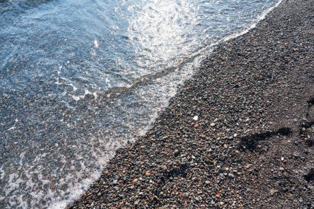 Téléchargez les photos : Détail de pavés dans l'eau transparente de la célèbre plage de Vlychada, Santorin. Contexte, pierre naturelle, texture. - en image libre de droit