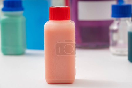 Téléchargez les photos : Bouteille en plastique avec liquide rouge. Échantillons de colorants alimentaires dans un laboratoire de qualité alimentaire. - en image libre de droit