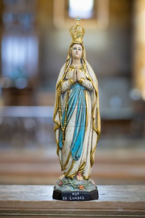 Foto de Estatua de Nuestra Señora de Lourdes en un fondo borroso de iglesia religiosa - Imagen libre de derechos