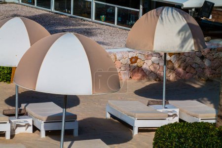 Umbrella and chair around swimming pool in hotel resort for travel and vacation