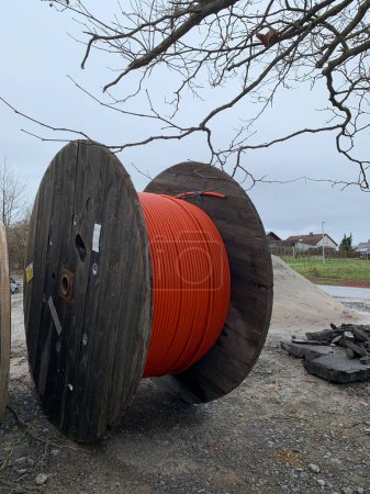 Photo for A wooden reels with an orange cable on a construction site. Side view - Royalty Free Image