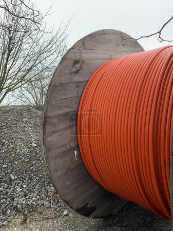 Photo for A wooden reels with an orange cable on a construction site. Side view close up - Royalty Free Image