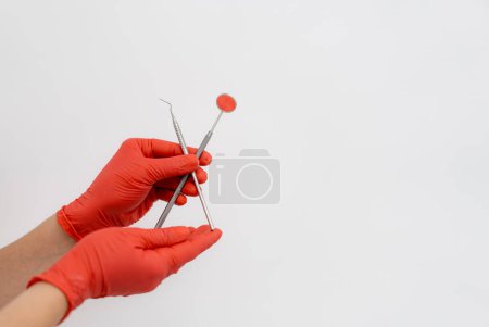 Dental tools on isolated background. Denistry instruments in gloved hands.