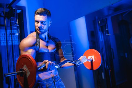 Téléchargez les photos : Athletic sporty man training hard. Muscular bodybuilder lifting huge weights. - en image libre de droit