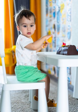 Téléchargez les photos : Jeune garçon célébrant avec un gâteau d'anniversaire. Un petit garçon assis à une table avec un gâteau - en image libre de droit