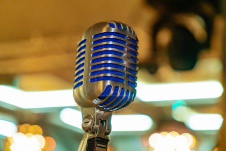 A close up of a microphone with blurry lights in the background