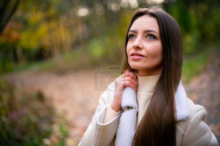 Photo for A woman standing in a serene forest with flowing hair. A woman with long hair standing in the woods - Royalty Free Image