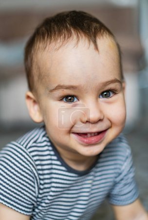 Téléchargez les photos : Un petit garçon qui sourit pour la caméra - en image libre de droit