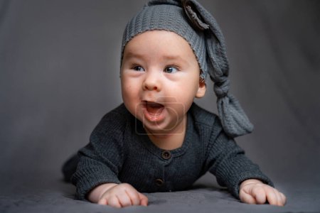 Téléchargez les photos : Un bébé portant un pull gris et un chapeau gris - en image libre de droit