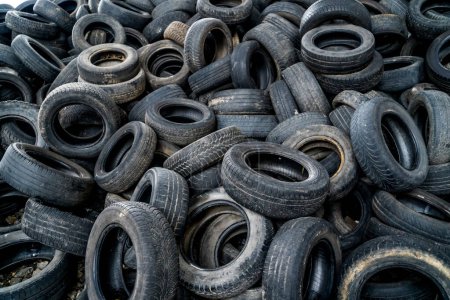 Foto de Almacenamiento de basura de neumáticos viejos. Neumáticos usados en el campo de basura de reciclaje. - Imagen libre de derechos