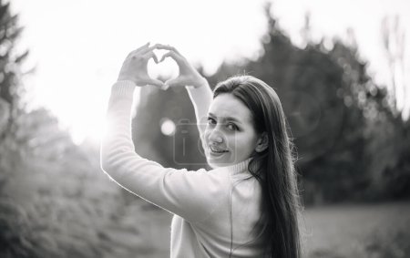 Photo for A woman holding a heart shaped object in her hands. Heartfelt Affection - Royalty Free Image