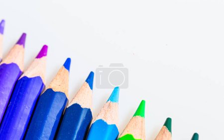 Téléchargez les photos : Un arc-en-ciel de couleurs : un affichage vibrant de crayons de couleur sur une toile propre. Une rangée de crayons de couleur alignés sur une surface blanche - en image libre de droit