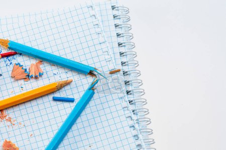 Téléchargez les photos : Une collection colorée de crayons et de crayons sur un carnet. Un carnet avec des crayons et des crayons dessus - en image libre de droit
