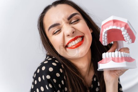 Téléchargez les photos : Une femme tenant un modèle de dent. L'importance de la santé buccodentaire : explorer la dentisterie à l'aide d'un modèle dentaire - en image libre de droit