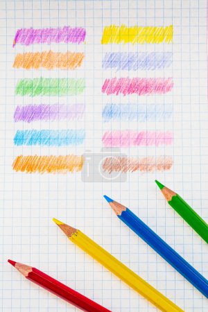 A Rainbow of Colored Pencils Creating a Colorful Composition. Colored pencils are lined up on a piece of paper