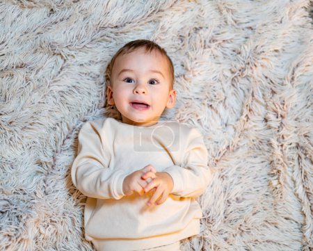 Photo for A Serene Moment: A Baby in Peaceful Slumber on a Soft, Plush White Blanket. A baby laying on a fluffy white blanket - Royalty Free Image