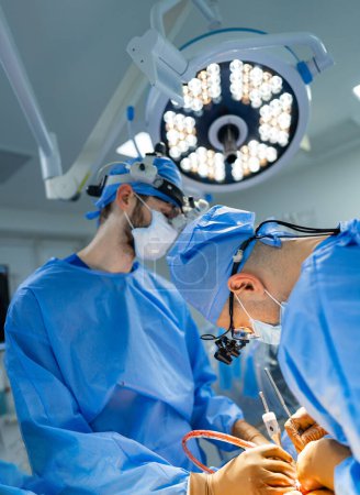Téléchargez les photos : Deux médecins dans une salle d'opération. Une procédure neurochirurgicale moderne dans une salle d'opération - en image libre de droit