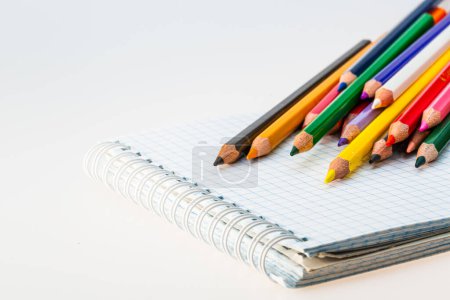 Téléchargez les photos : Un tas de crayons assis sur un cahier. Un paquet de crayons assis sur un cahier - en image libre de droit