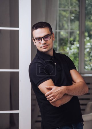 Photo for A Man Leaning Against a Wall with Crossed Arms. A man leaning against a wall with his arms crossed - Royalty Free Image