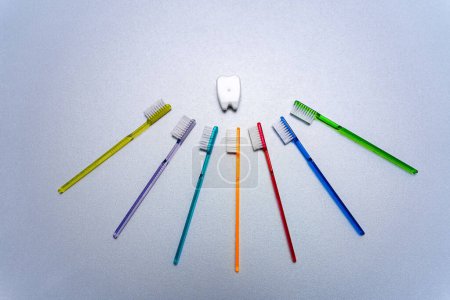 Téléchargez les photos : Brosses à dents colorées disposées dans une formation circulaire. Un groupe de brosses à dents de différentes couleurs disposées en cercle - en image libre de droit