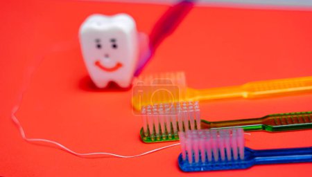 Téléchargez les photos : Une brosse à dents, un dentifrice et un tube de dentifrice sur un rouge - en image libre de droit
