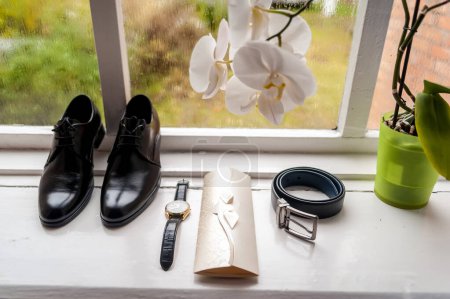 Ein faszinierendes Bild, das den Reiz und Charme schwarzer Schuhe einfängt, die anmutig auf einem sonnenbeschienenen Fensterbrett thronen.