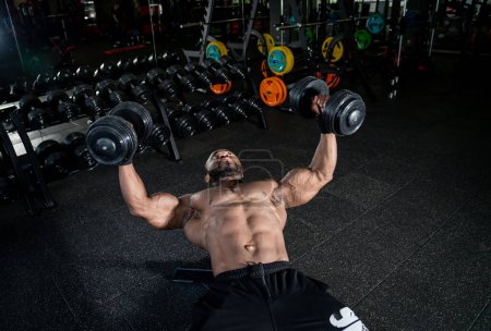 Téléchargez les photos : Puissant entraînement en salle de gym par un homme torse nu musclé. Homme fort athlétique travaillant. - en image libre de droit