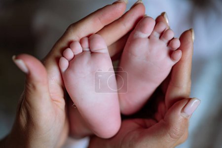 Photo for Close-Up of Person Holding Babys Feet, Cherishing Precious Moments. A tender moment captured in a close-up photo of a person cradling a babys tiny feet with love and care. - Royalty Free Image