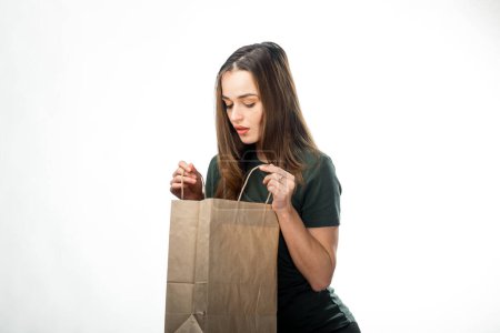 Photo for Young woman holding shopping bag on white background - Royalty Free Image