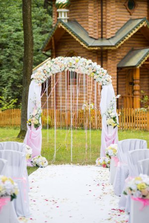 Wedding arch and chairs for guests at wedding ceremony.