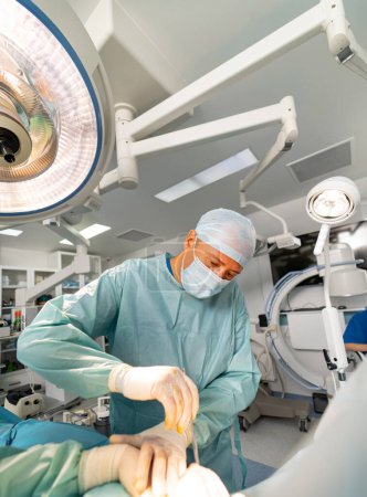 Chirurgie moderne Klinik performing. Professionelle gutaussehende Ärztin operiert.
