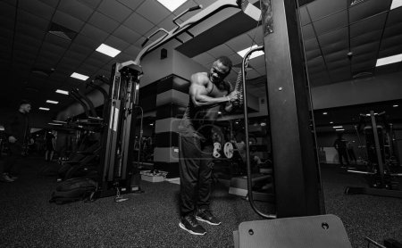 Foto de Un joven fisicoculturista haciendo ejercicio en el gimnasio. Cuerpo atlético con entrenamiento muscular. - Imagen libre de derechos
